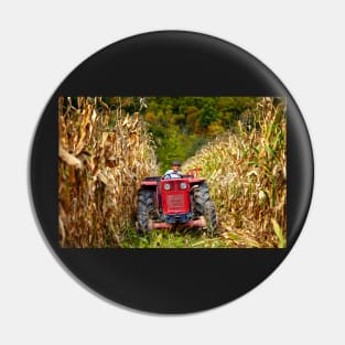 Old farmer driving the tractor in the cornfield Pin