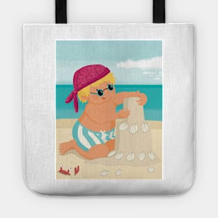 Cute little boy is on vacation building a sand castle on the beach Tote