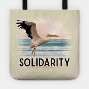 Solidarity Pelican Flying Over the Sea Tote