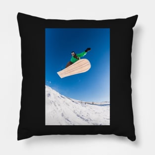 Snowboarder jumping against blue sky Pillow