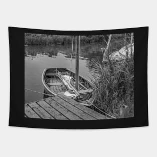 Small wooden boat moored to a quay heading on the Norfolk Broads Tapestry