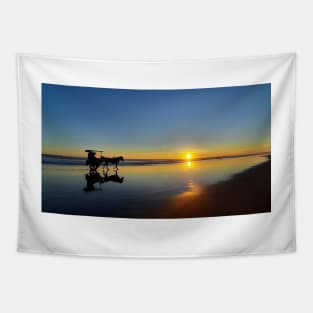 A silhouetted horse-drawn carriage on Parangtritis beach at sunset 1 Tapestry