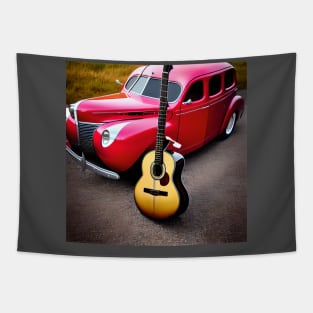 An Acoustic Guitar Standing In Front Of A 1940’s Red Colored Car. Tapestry