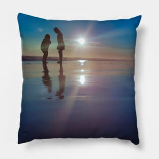 Silhouetted people in a row on a sand beach. Pillow