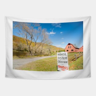 Honor system sign for tomatoes in rural New England beside an American style red barn by a river. Tapestry