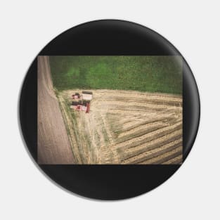 Aerial view of combine-harvester and tractor working in the field Pin