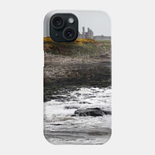 Dunstanburgh castle with rough waves battering the coast in Northumberland, UK Phone Case