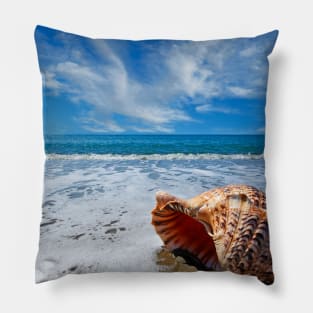 Beach with conch shell under blue sky Pillow