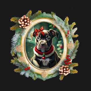 A cute black puppy dog wearing a festive bow and dog collar, in a winter Christmas picture frame with pinecones and winter berries T-Shirt