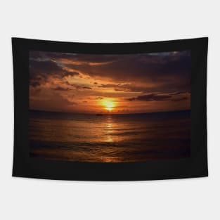 Mesmerizing vertical shot of the sun setting behind the clouds over the calm ocean Tapestry