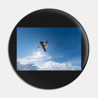 Snowboarder jumping against blue sky Pin