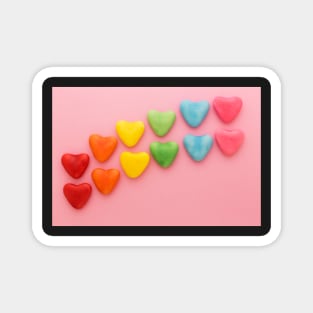 Heart-shaped Candy arranged in rainbow order on a pink background Magnet