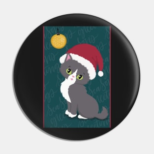 Cute Christmas card with a little kitten in a Christmas hat looking at a bauble. Pin