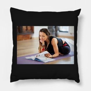 Young woman reading a yoga book Pillow