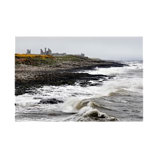 Dunstanburgh castle with rough waves battering the coast in Northumberland, UK T-Shirt