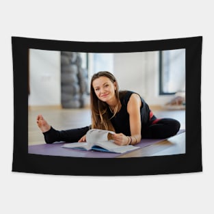 Young woman reading a yoga book Tapestry