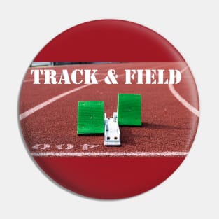 Track and field written above green starting blocks on a red track Pin