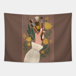 Woman's hand holding paint brushes surrounded by flowers Tapestry