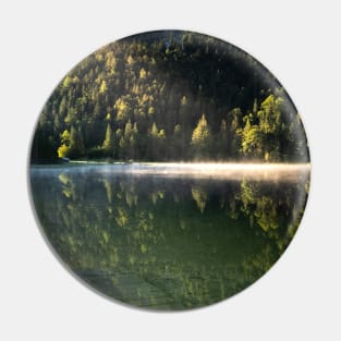 Ray of sunlight on misty lake. Wooden pier in front. Amazing shot of the Ferchensee lake in Bavaria, Germany. Scenic foggy morning scenery at sunrise. Pin