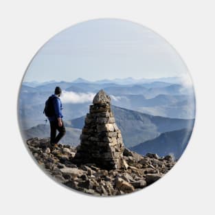 Climber passes a cairn on the summit of Ben Nevis Pin