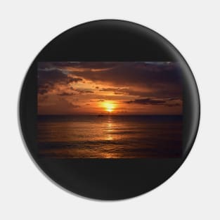 Mesmerizing vertical shot of the sun setting behind the clouds over the calm ocean Pin