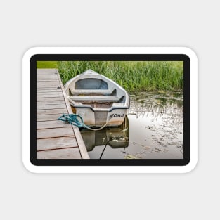 Boat tied to wooden staging on the Norfolk Broads Magnet