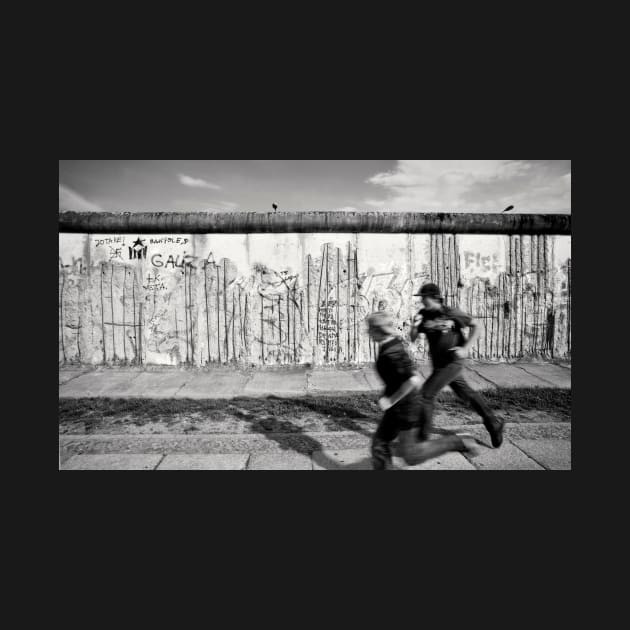 Two kids running along the remains of the Berlin Wall, Berlin, Germany by Reinvention