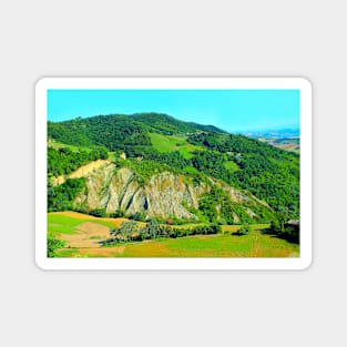 Scenery from Castignano with a hill of ravines and green colours, a valley and the Sibillini Magnet