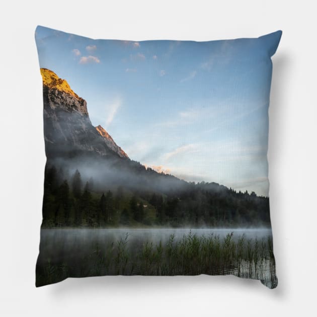 Mist on Alp mountain at Ferchensee. Amazing shot of the Ferchensee lake in Bavaria, Germany, in front of a mountain. Scenic foggy morning scenery at sunrise. Pillow by EviRadauscher