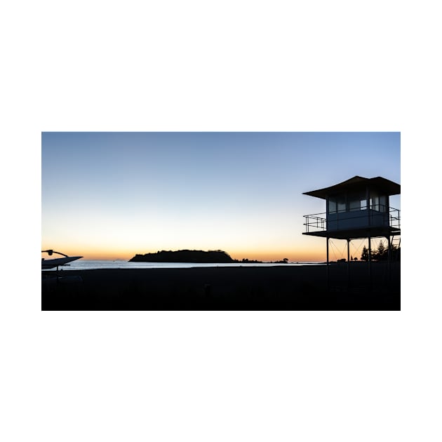 Silhouetted against golden glow of sunrise lifesafers lookout on Mount Maunganui beach New Zealand. by brians101