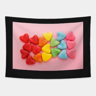 Heart-shaped multi-colored candy ordered in rainbow colors and shape on a pink background Tapestry