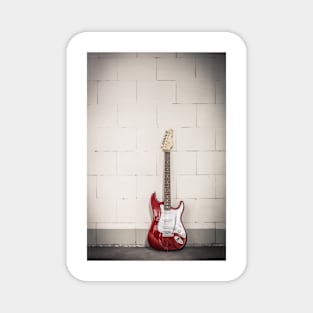 Red electric guitar against white brick wall background Magnet