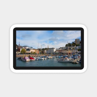 A sunny view across the boats moored in the harbour of the Devonshire seaside town of Torquay. Magnet