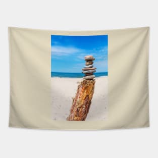 Stack of stones on the beach against blue sky Tapestry