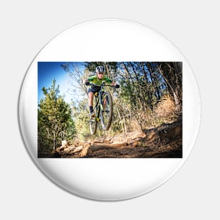 Close up image of a mountain biker getting air Pin