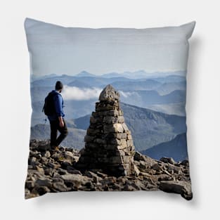 Climber passes a cairn on the summit of Ben Nevis Pillow