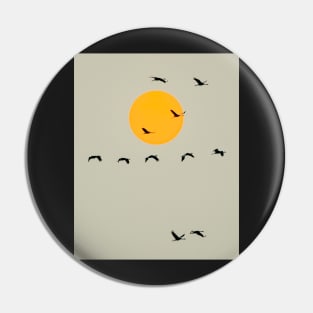 Common Cranes Flying in Front of Orange Setting Sun Pin