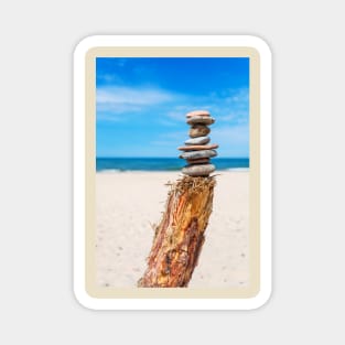 Stack of stones on the beach against blue sky Magnet