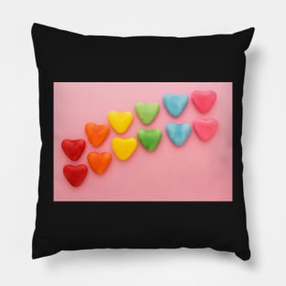 Heart-shaped Candy arranged in rainbow order on a pink background Pillow