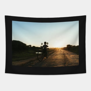 Silhouette of Boy Riding Bicycle at Sunset in Burmese Countryside Tapestry