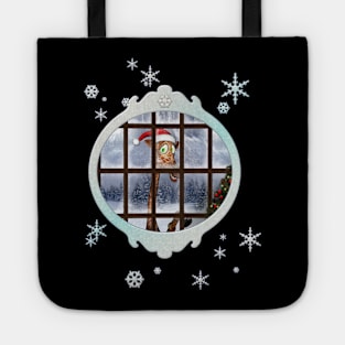 Funny giraffe  with christmas hat looks through the window Tote