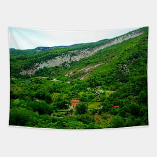 View in Castel Trosino at a ridge of rough mountain standing above human settlements Tapestry