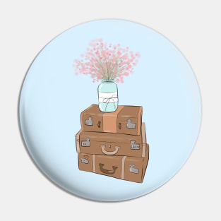 Pile of baggage with a jar with flowers Pin