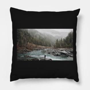 A man standing on jagged rocks in a fast-flowing river in the wilderness Pillow