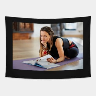 Young woman reading a yoga book Tapestry