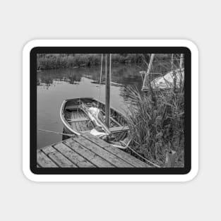 Small wooden boat moored to a quay heading on the Norfolk Broads Magnet