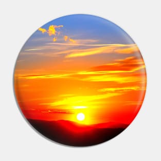 Dramatic sunset on the red-blue sky with the setting sun and clouds Pin