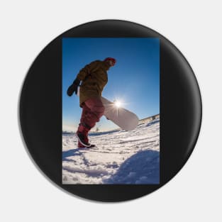 Snowboarder walking against blue sky Pin