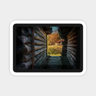 View to the autumn forest through log huts Magnet