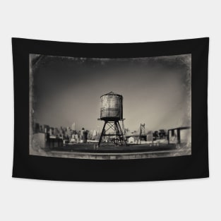 Sepia-toned image of a rusty water tower on a rooftop of Queens, in New York City, with the Queensboro Bridge and the Manhattan skyline in the background. Tapestry